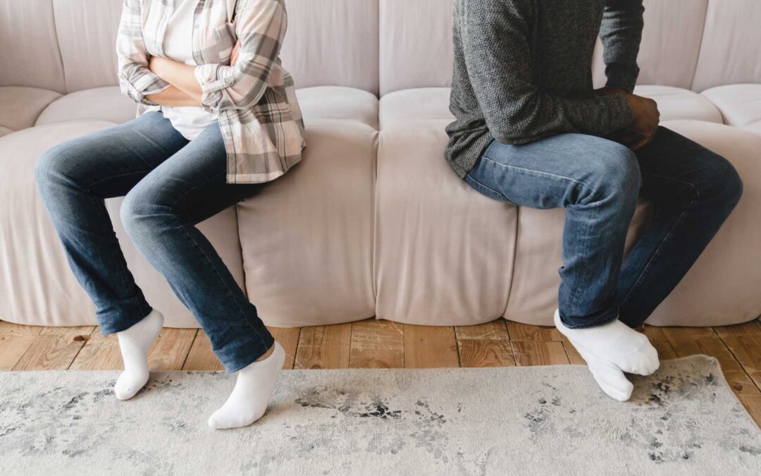 watching porn in relationship, a couple in a fight sitting on a sofa