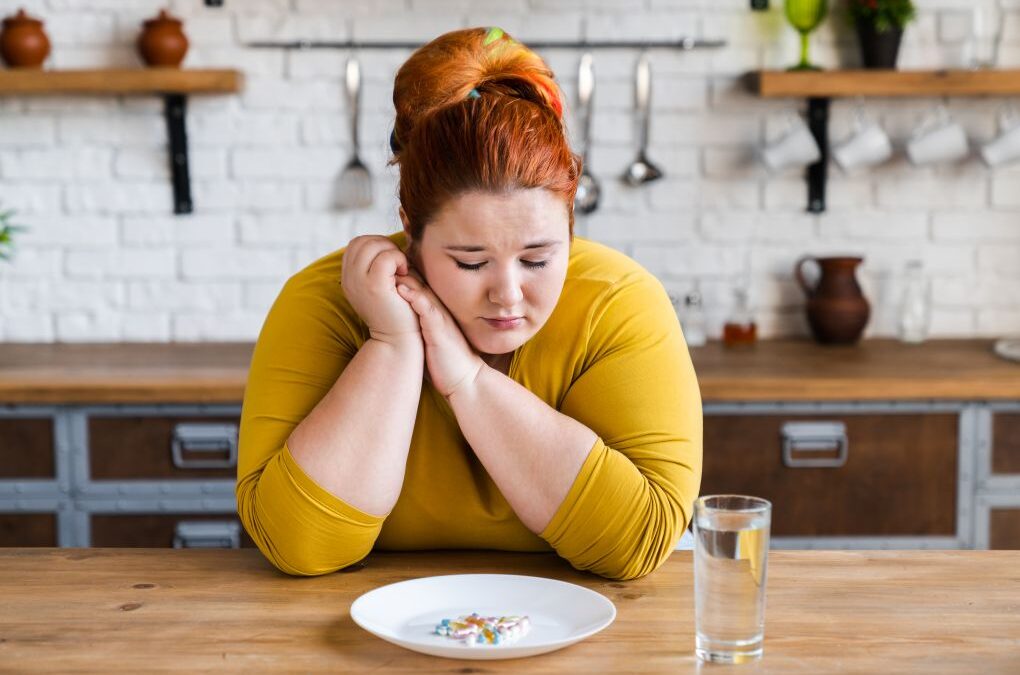 stress hormones and weight gain, a woman looking sadly at food
